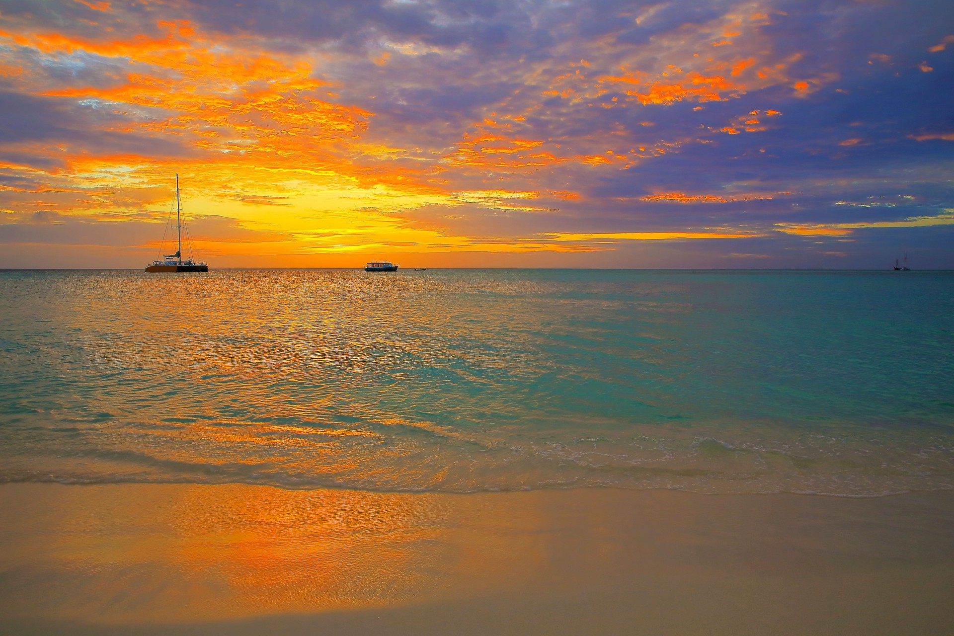 Idyllic tropical Beach at dramatic sunset with boats and yacht, Bahamas summer paradise, Caribbean sea